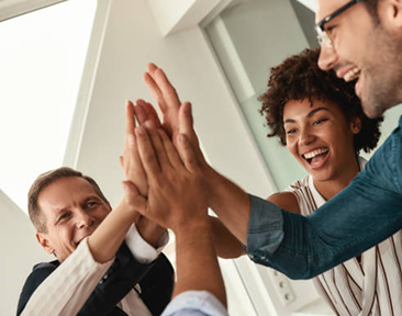 Team high-fiving in office